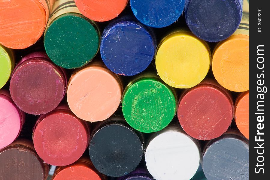 A closeup of the bottoms of a stack of colorful crayons. A closeup of the bottoms of a stack of colorful crayons.