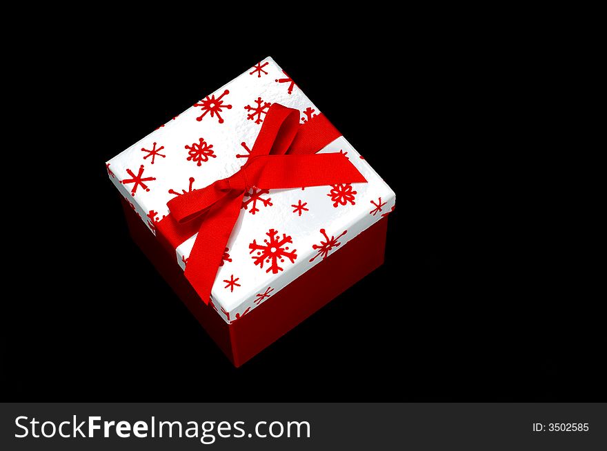 Red and white gift box on black background with copy space