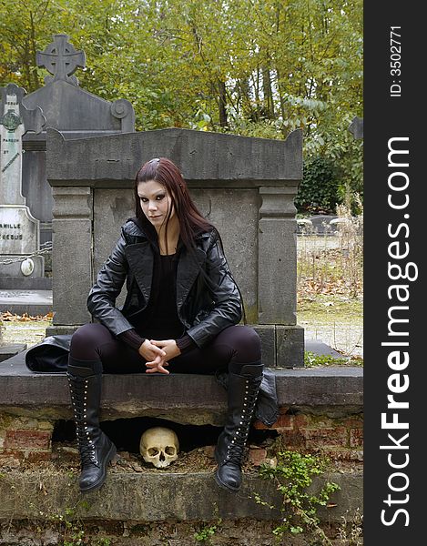 Woman in a european ancient cemetery with human skull. Woman in a european ancient cemetery with human skull.