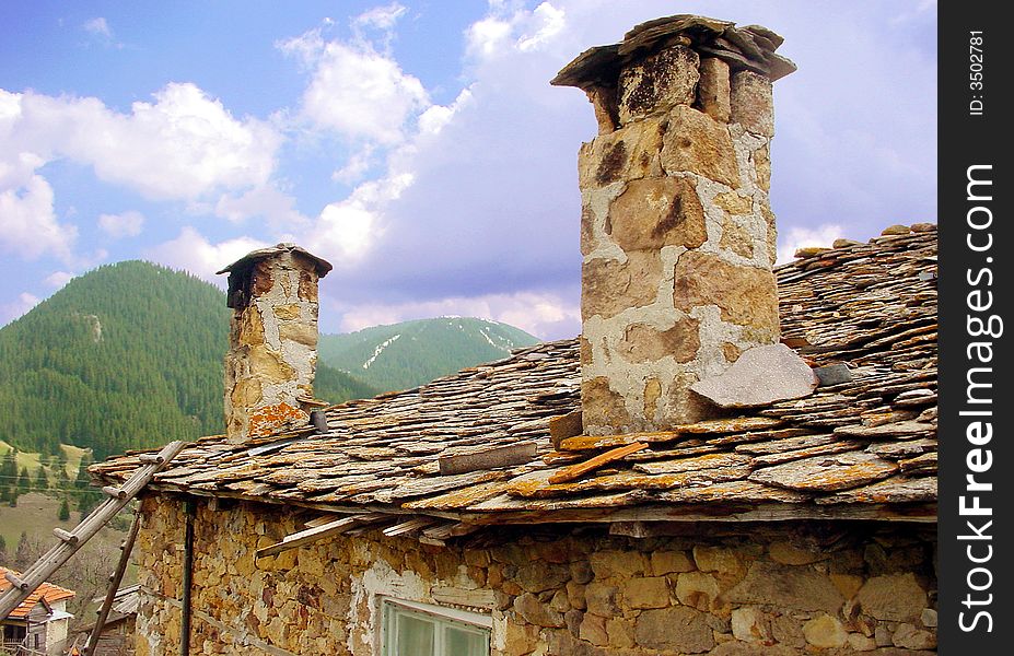 Stone Tiles Roof and Chimneys of an Old Mountain House, Rhodopes Mountain, Bulgaria. Stone Tiles Roof and Chimneys of an Old Mountain House, Rhodopes Mountain, Bulgaria