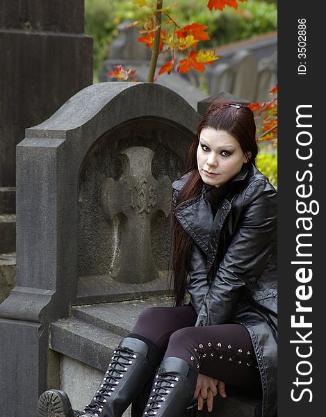 Woman sitting on a tomb in a european ancient cemetery . Woman sitting on a tomb in a european ancient cemetery .