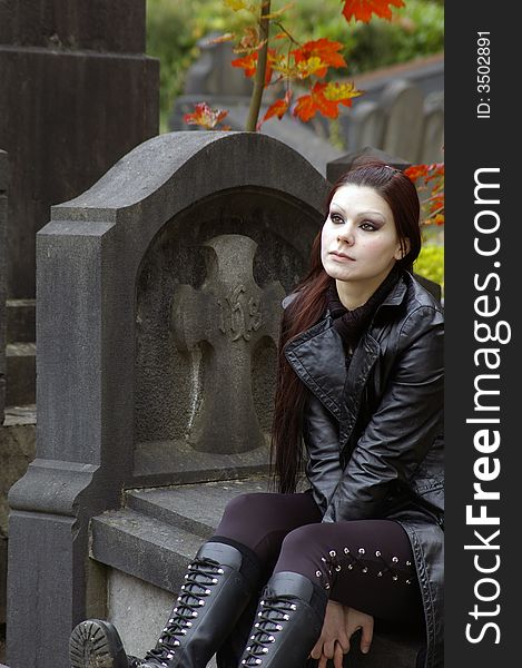 Woman sitting on a tomb in a european ancient cemetery . Woman sitting on a tomb in a european ancient cemetery .