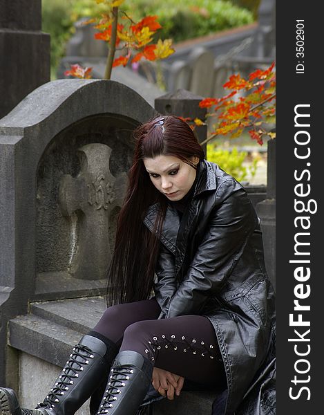 Woman sitting on a tomb in a european ancient cemetery . Woman sitting on a tomb in a european ancient cemetery .