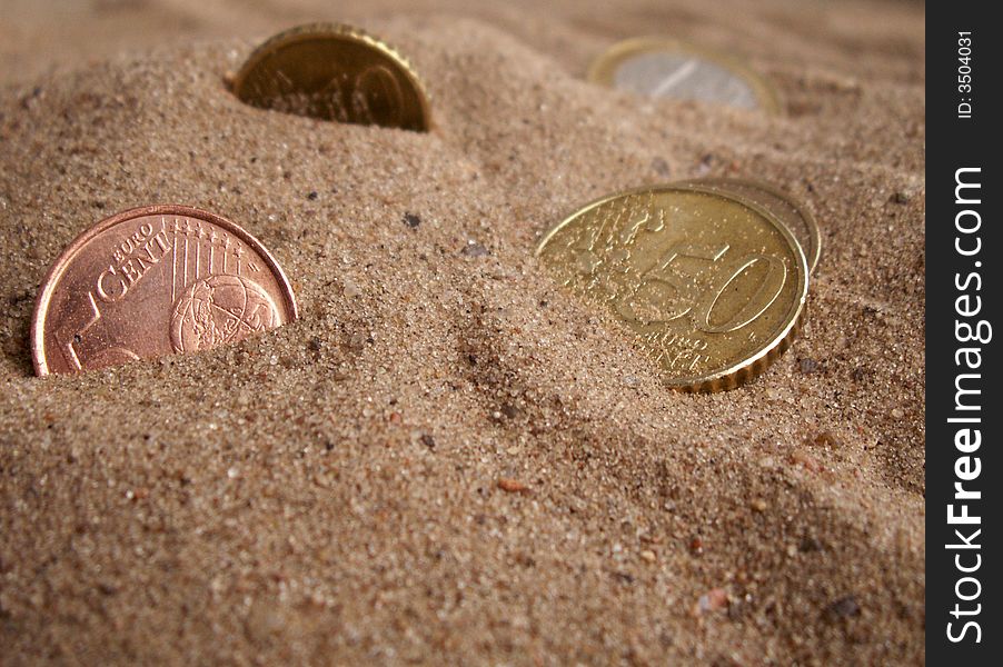 Five european coins on background with sand. Five european coins on background with sand