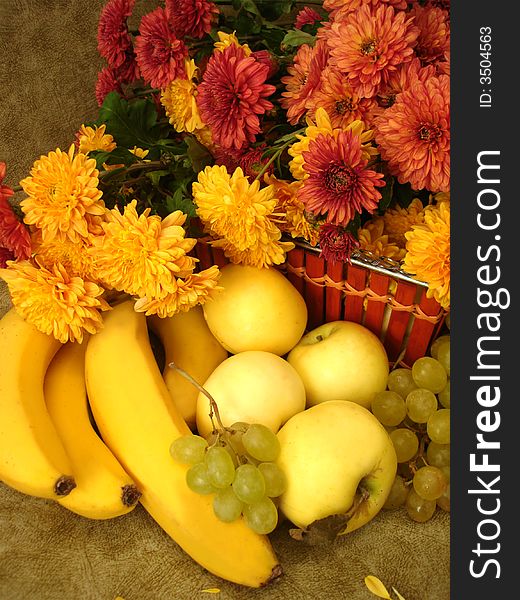 Harvest still-life: fruits on basket and flowers