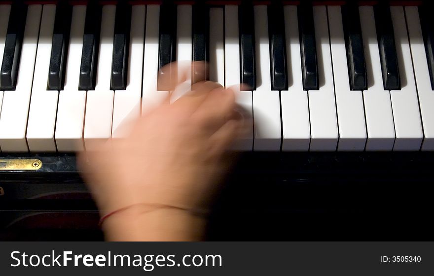 Close-up of a hand playing a chord on a piano keyboard. Close-up of a hand playing a chord on a piano keyboard