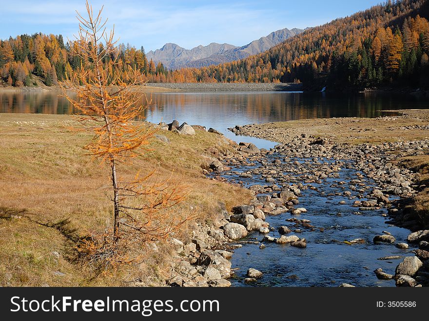 Landscape with a limpid stream and a lake. Mountain in autumn with warm colors. Landscape with a limpid stream and a lake. Mountain in autumn with warm colors.