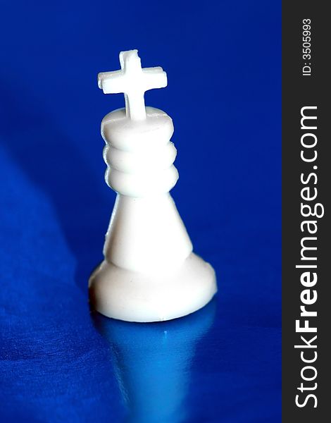 White chess king stands on blue background