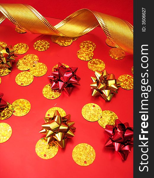 Golden celebratory ribbon and bows on red background