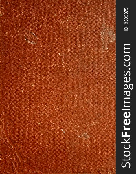 Close up of a red book cover with a weathered, old look