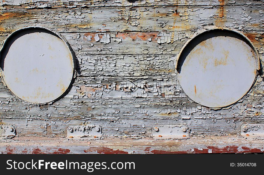 Iron portholes on the ancient wooden background flaking. Iron portholes on the ancient wooden background flaking.