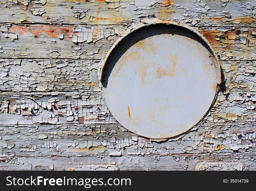 Old iron porthole and exfoliated paint on old wood. Old iron porthole and exfoliated paint on old wood.