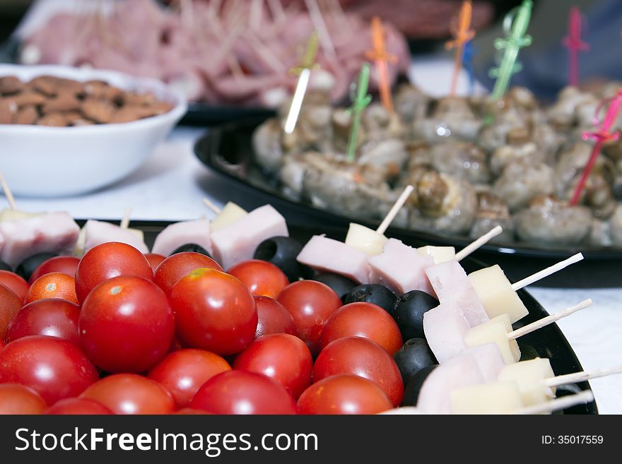 Cold snacks on the table : cherry tomatoes, canapes and meat snacks