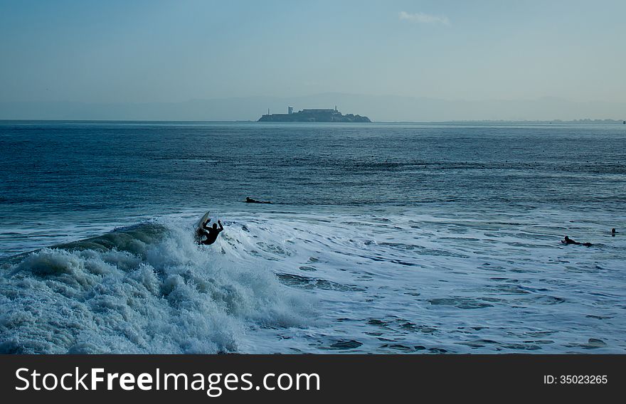 A few surfers on the San Francisco Bay, in front of the Isle of Alcatraz. A few surfers on the San Francisco Bay, in front of the Isle of Alcatraz