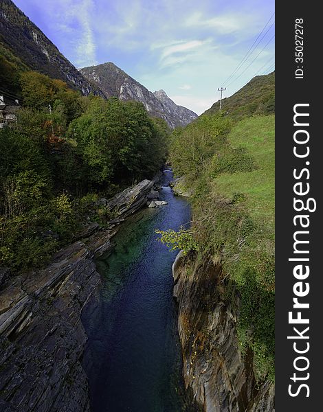 The ancient Ponte dei Salti spans the incredibly green-blue waters of the Verzasca River in the Ticino area of Switzerland. This view from the bridge shows the intense colours of the river. The ancient Ponte dei Salti spans the incredibly green-blue waters of the Verzasca River in the Ticino area of Switzerland. This view from the bridge shows the intense colours of the river.