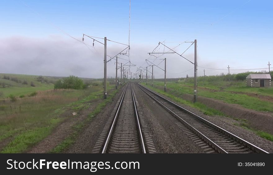 View from the last car of a train. Rails run away. Train departs from the clouds in good weather. Real sound. View from the last car of a train. Rails run away. Train departs from the clouds in good weather. Real sound