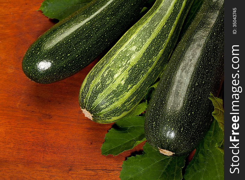 Fresh green zucchini on wooden background