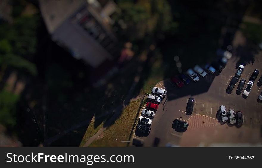 Summer. Sunny weather. View down from the window of the twentieth floor of a house. Car parking. Timelapse. Tilt Shift. Summer. Sunny weather. View down from the window of the twentieth floor of a house. Car parking. Timelapse. Tilt Shift