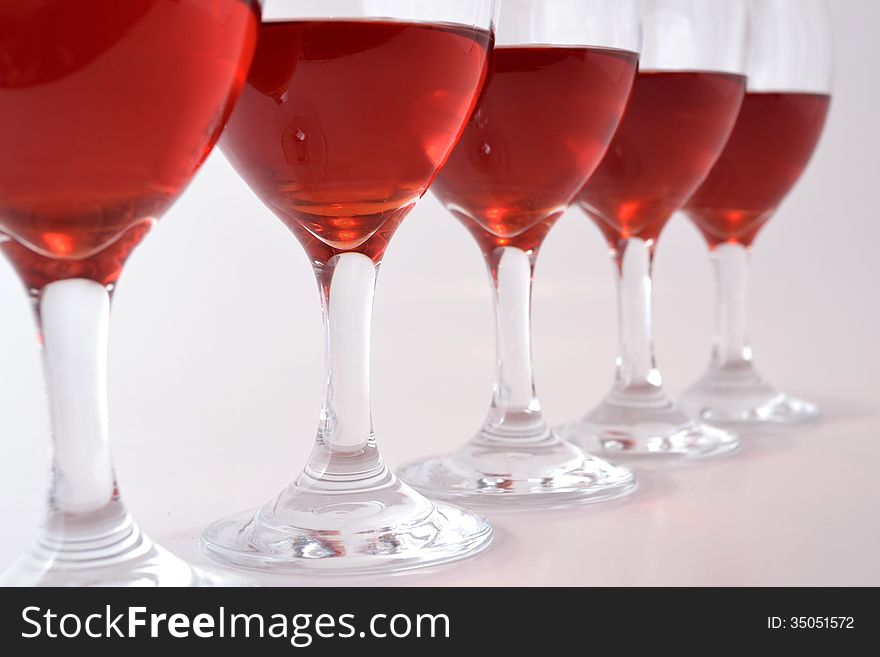 Glasses of red wine on light gray background