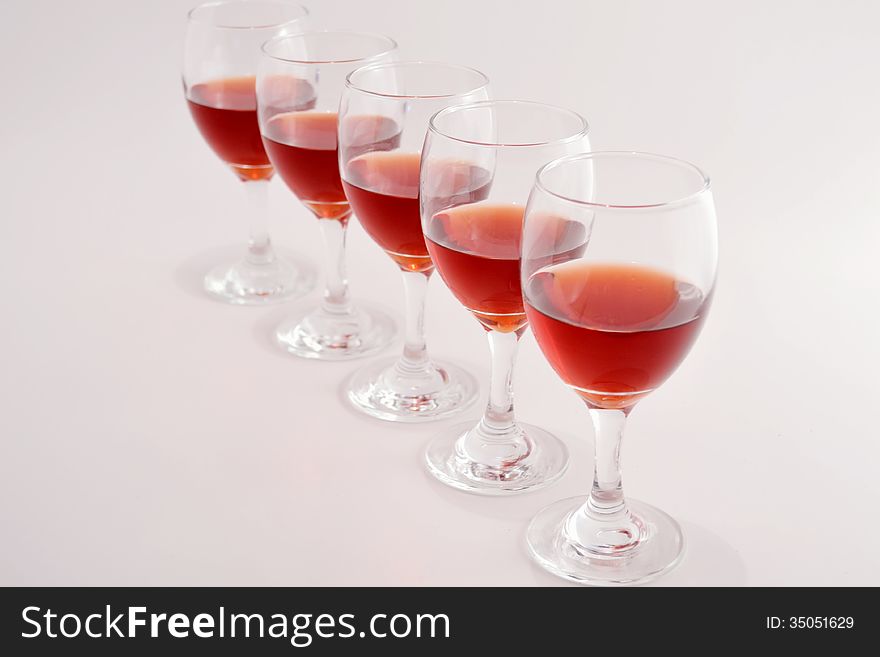 Glasses of red wine on light gray background