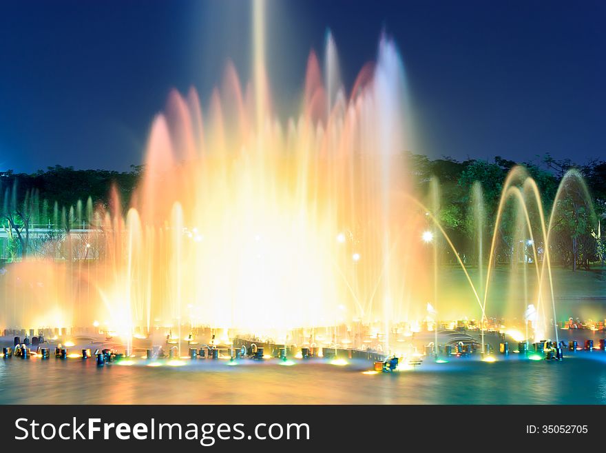 Fountain outdoors show changing color in the park. Take photo with long exposure effect.