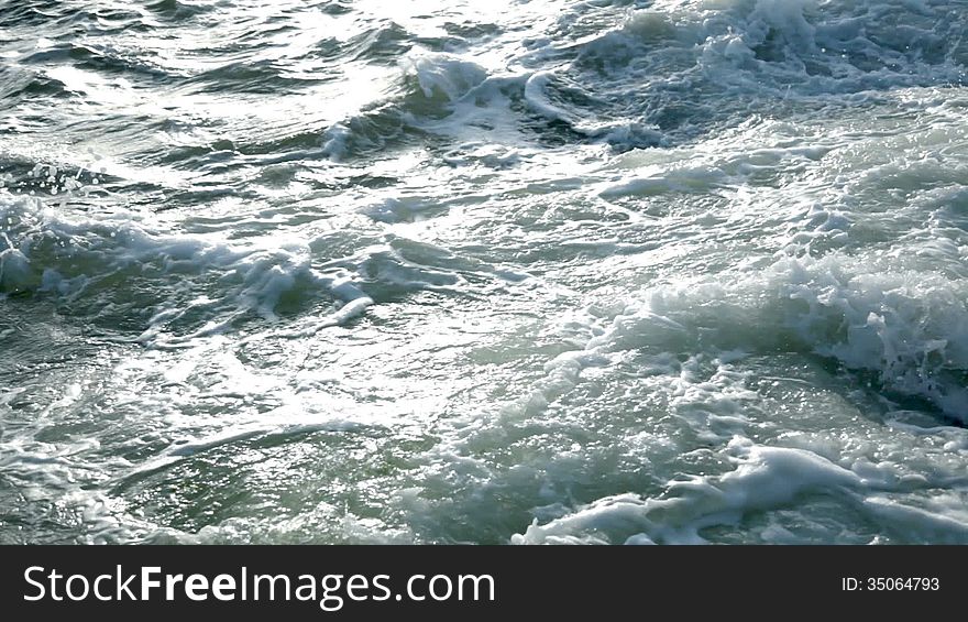 Dusk. Ocean waves crash on the coastal rocks and bubbling. Whirlpools. Spray. Close-up. Dusk. Ocean waves crash on the coastal rocks and bubbling. Whirlpools. Spray. Close-up