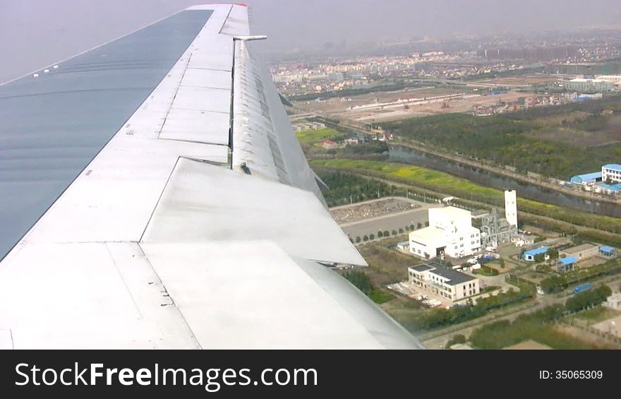 Landing of aircraft at the airport in Shanghai. A view from the porthole on the wing. Fast speed. Landing of aircraft at the airport in Shanghai. A view from the porthole on the wing. Fast speed