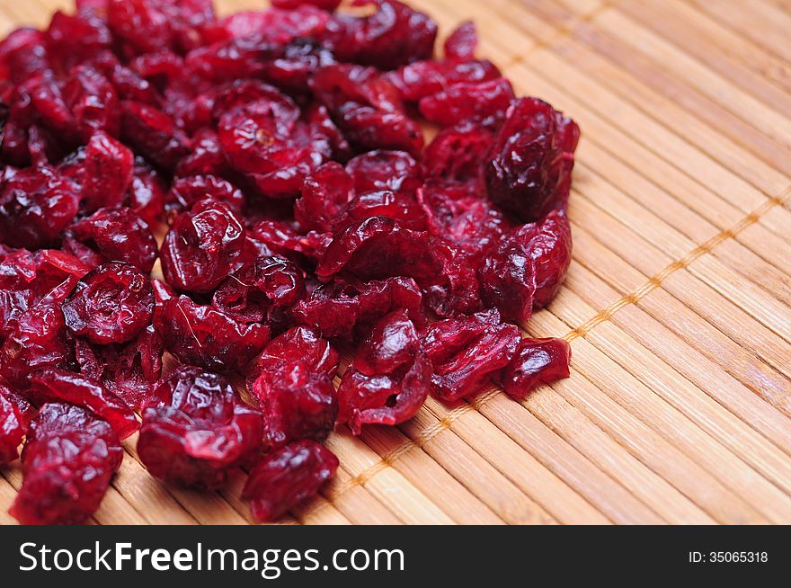 Bunch of dried cranberries over wooden board