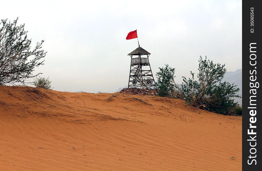 Observation tower with a red flag in the desert. Observation tower with a red flag in the desert