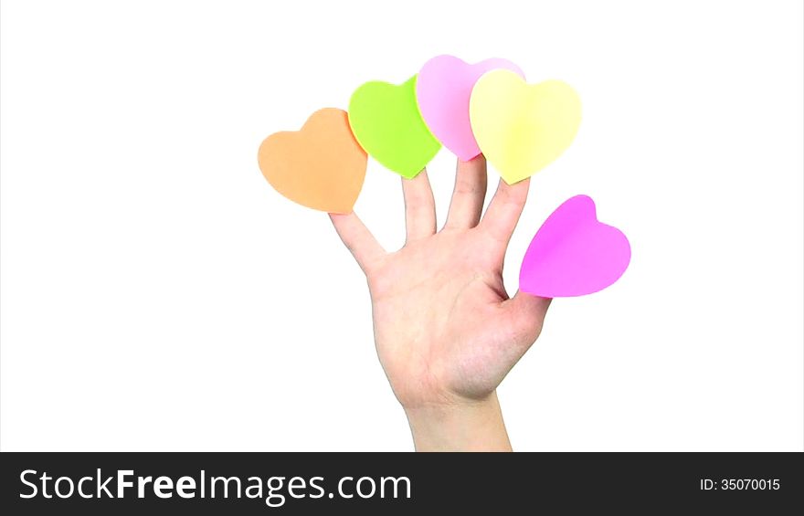 On the fingers of the women's hands are glued five colorful paper labels in the form of hearts. Hand waving on a white background. On the fingers of the women's hands are glued five colorful paper labels in the form of hearts. Hand waving on a white background
