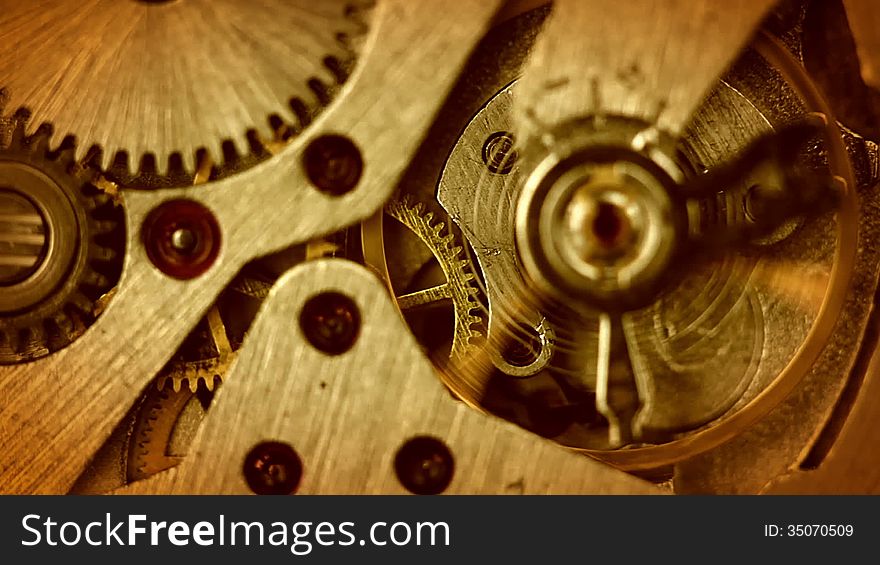 The pendulum and gears of the old watch on the move. Close-up. The focus on the middle of the mechanism. The pendulum and gears of the old watch on the move. Close-up. The focus on the middle of the mechanism