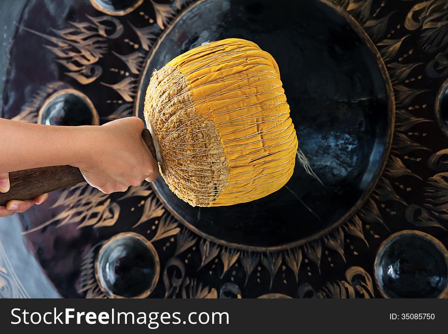 Hand hit big gong in temple background