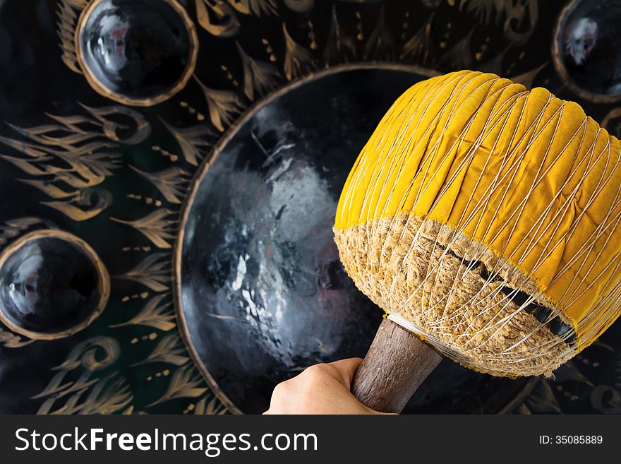 Hand hit big gong in temple background