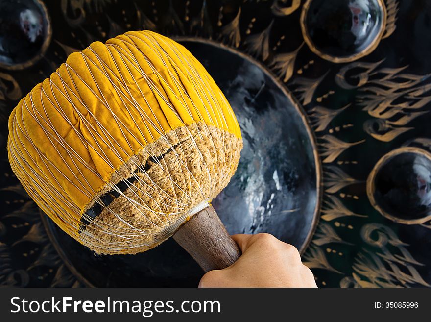 Hand hit big gong in temple