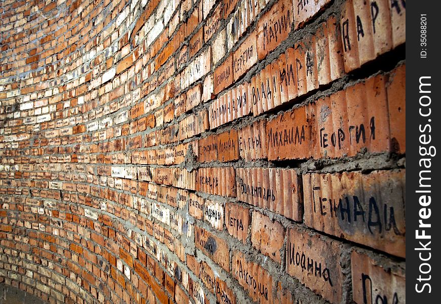 Brick wall with cyrillic names from orthodox church