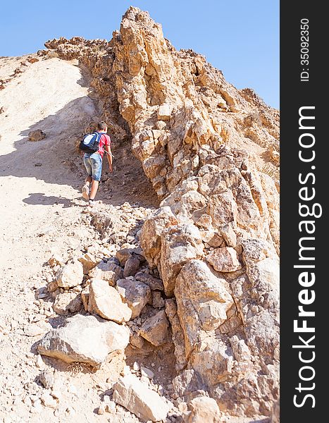 Guy climbs on a low hill summer day