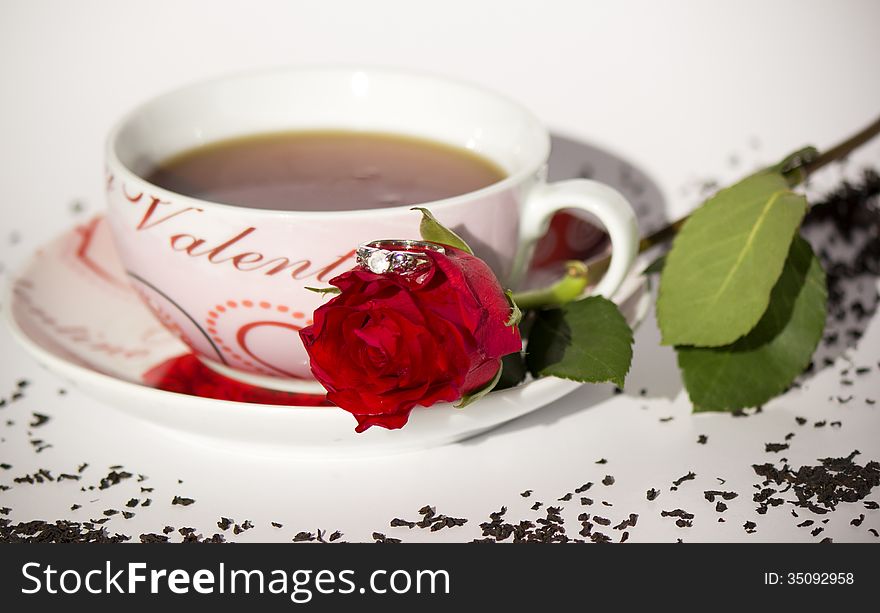 Teapot with rose on white background.