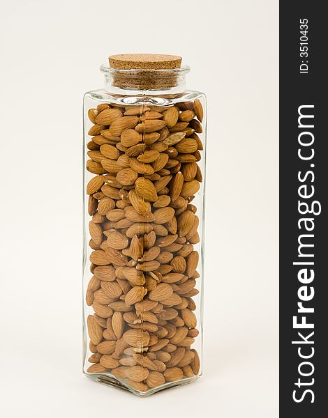 A tall glass jar, full of almonds, one of the healthiest snacks. A tall glass jar, full of almonds, one of the healthiest snacks.