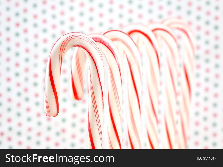 Row of Candy Canes on Red and Green Dotted Background. Row of Candy Canes on Red and Green Dotted Background