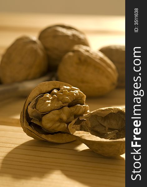 Group of walnuts on wooden table, in warm morning light.