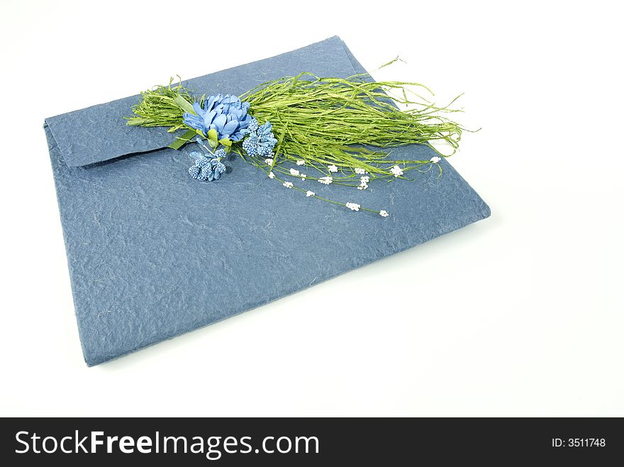 Azure envelope in raw paper, closed with beautiful flowers composition. Azure envelope in raw paper, closed with beautiful flowers composition.