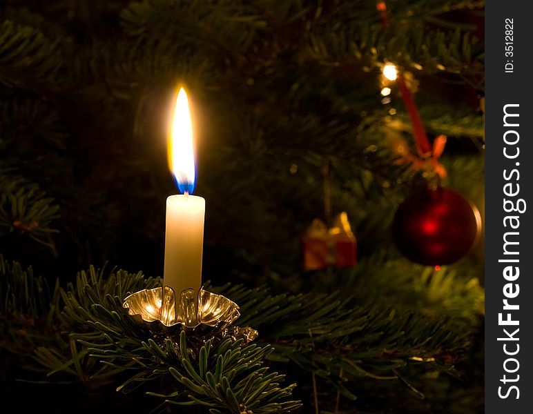 Single candle focus isolated on traditional Xmas tree. Single candle focus isolated on traditional Xmas tree.