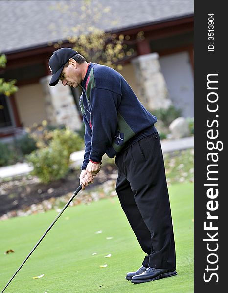 A male golfer plays a game on a beautiful fall day. A male golfer plays a game on a beautiful fall day.