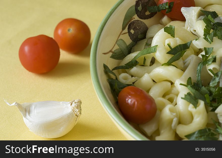 Pasta with garlic, tomato, artichoke and parsley served in a dish. Pasta with garlic, tomato, artichoke and parsley served in a dish