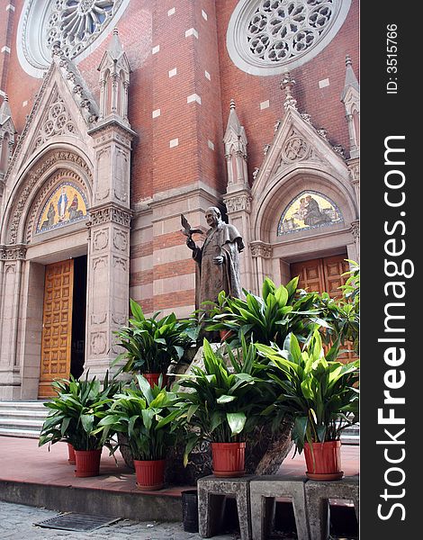 Catholic church with a monument and exotic plants. Catholic church with a monument and exotic plants