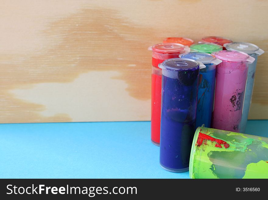 Paint Bottles against a wooden background on a blue sheet. Paint Bottles against a wooden background on a blue sheet