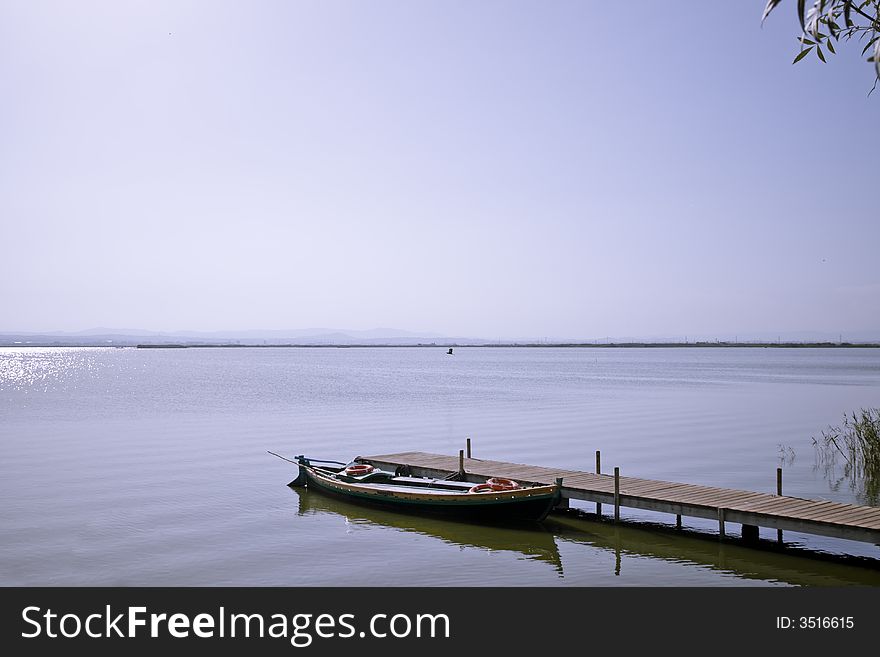 A boat tied in a footbridge, taken in the Albufera, Valencia. A boat tied in a footbridge, taken in the Albufera, Valencia.