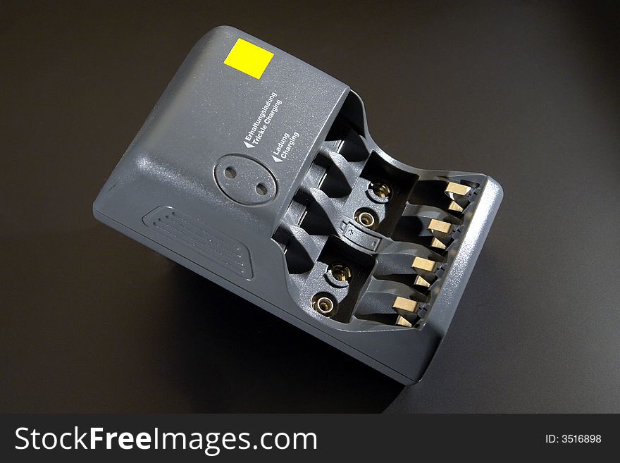 A battery charger isolated on black background. Clipping path included