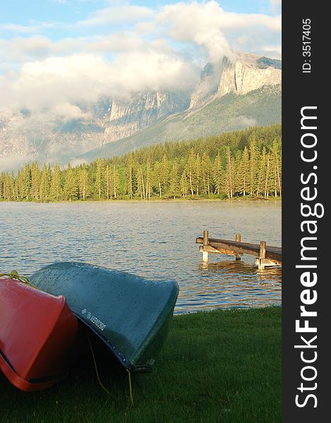 Canoes beside a lake with mountains in the background. Canoes beside a lake with mountains in the background