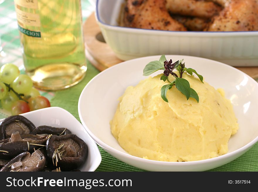 Mash potato with basil heaped up and smoothed off in a white ceramic bowl